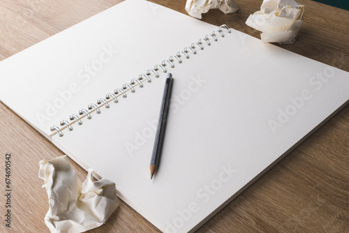 open sketchbook with blank sheets on a wooden table with paper bags and glasses, concept of ideas in a notebook, making notes, back to school, art and drawing photo
