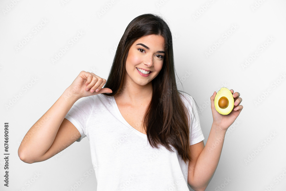 Young Brazilian woman holding an avocado isolated on white background proud and self-satisfied Young Brazilian woman holding an avocado isolated on white background proud and self-satisfied