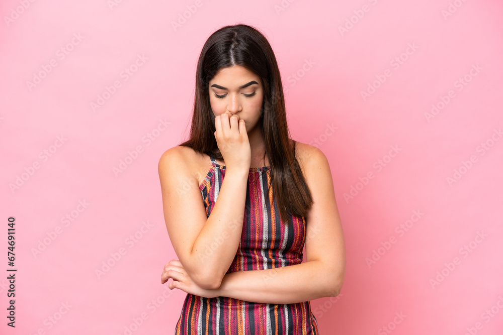 Young Brazilian woman isolated on pink background having doubts Young Brazilian woman isolated on pink background having doubts