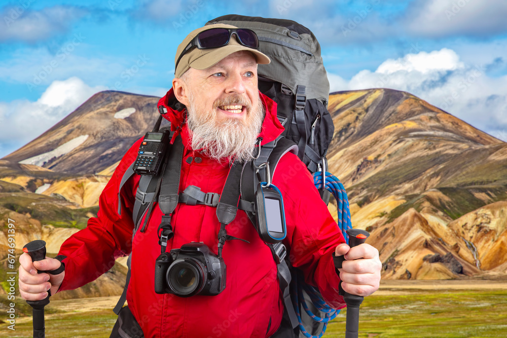 happy bearded man traveler with hiking equipment against the backdrop of a mountain landscape. travel, hiking and adventure