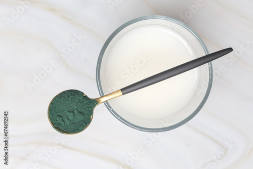 Green powder in the spoon, spirulina, alage, chlorophyll or matcha. Concept of nutritional supplement, dieting, detox, preventive healthcare and healthy lifestyle.