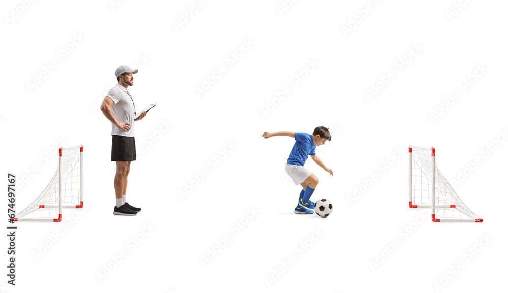 Boy training football with a coach on mini goals Boy training football with a coach on mini goals