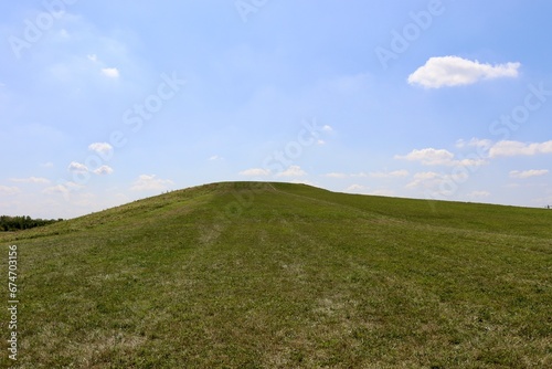 The green grass hill in the countryside on a sunny day.