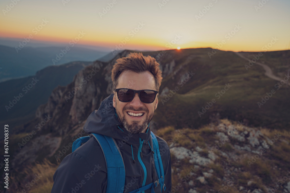 A smiling male traveler solo hiking the mountain adventure travel.