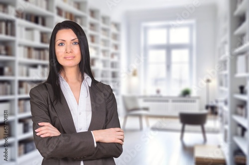 Confident young business woman with arms crossed in the office, AI generated image