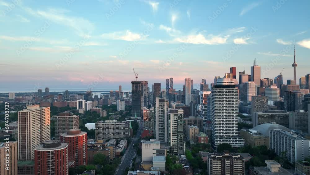 A forward-tracking drone captures the glowing skyline of downtown Toronto at dusk, with urban architecture stretching towards the horizon. A forward-tracking drone captures the glowing skyline of downtown Toronto at dusk, with urban architecture stretching towards the horizon.