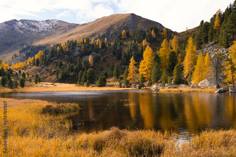 The landscape of autumn forest with mountain lake nature background.