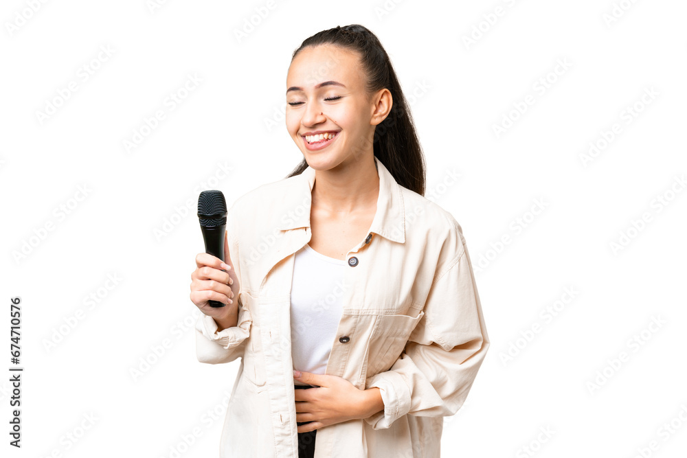 Young singer woman picking up a microphone over isolated chroma key background smiling a lot Young singer woman picking up a microphone over isolated chroma key background smiling a lot