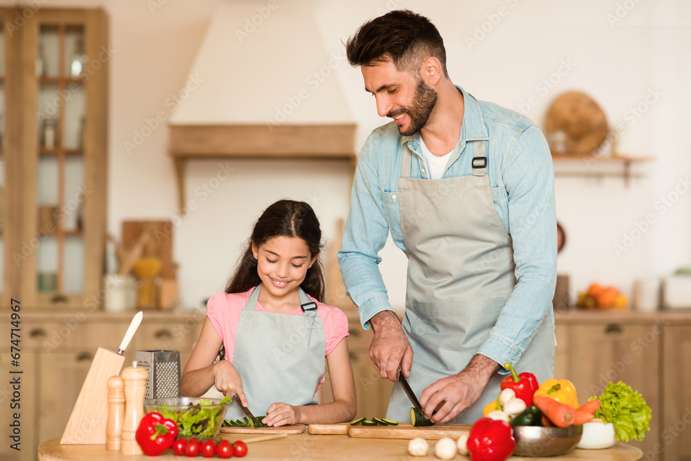 Dad and daughter chopping veggies together