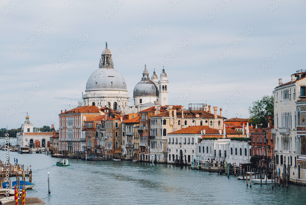 Famous view of Venice Grand Canal with Saint Mary of Health dome on sunny day from Ponte dell'Accademia bridge. Italian travel destination and landmark, tourist attraction.