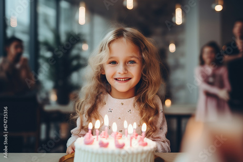 Little girl blowing out candles on his birthday cake.