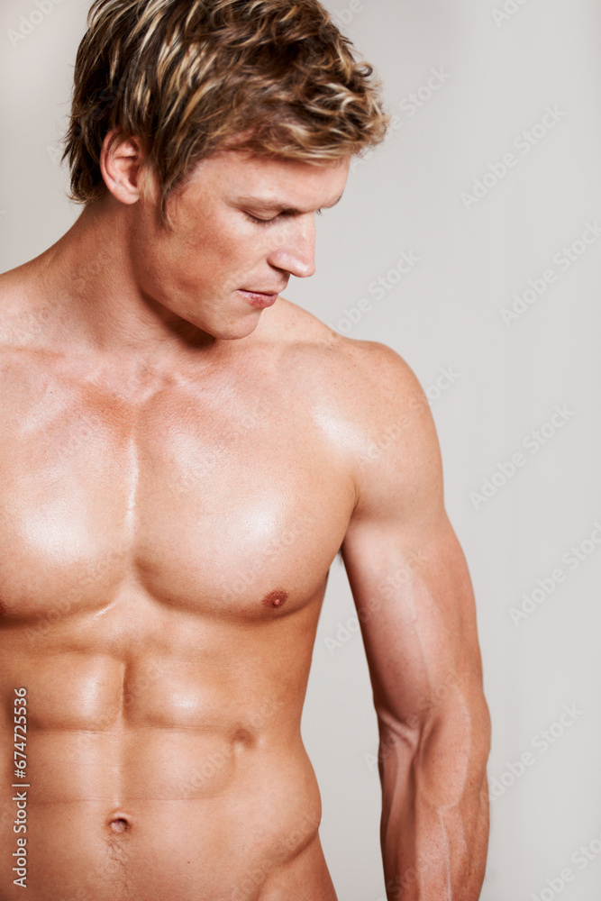 Body, strong and muscles of a shirtless man in studio isolated on a gray background for health or fitness. Sexy, wellness and a young model, personal trainer or coach feeling confident in his skin