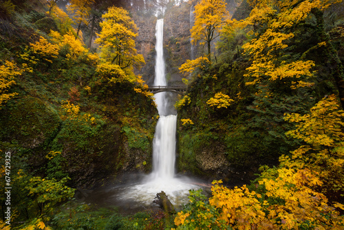 Beautiful waterfall landscape of Multnomah Falls during peak autumn foliage color, Columbia River Gorge, Oregon