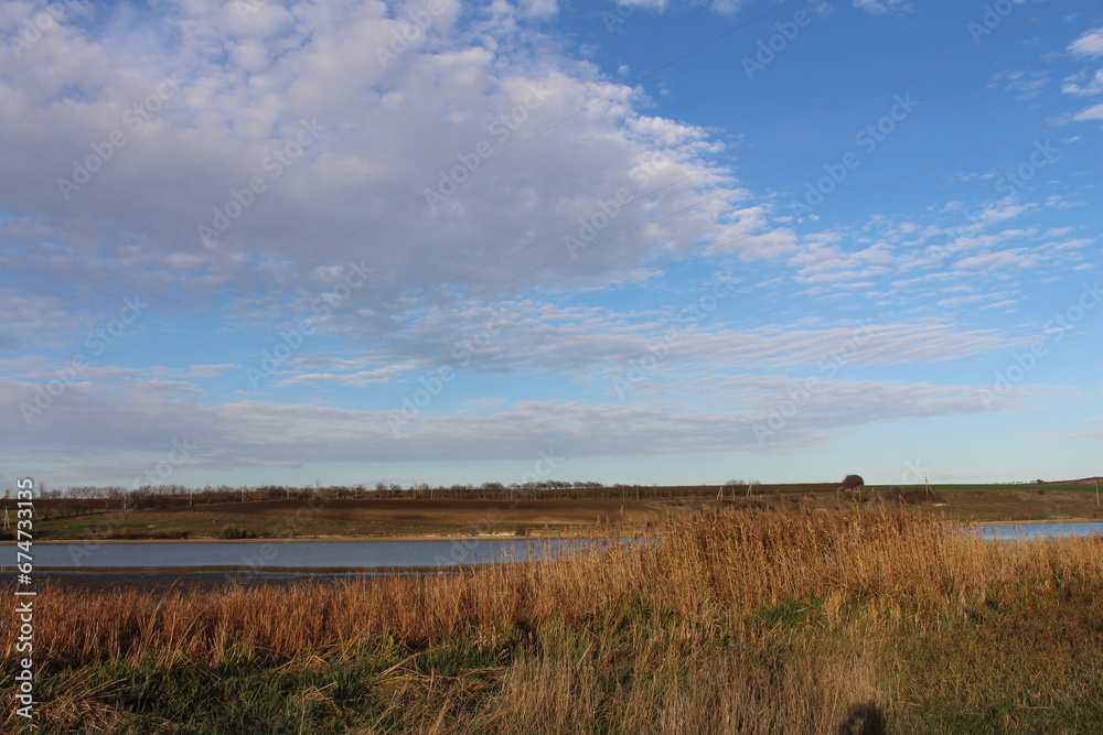 A field with grass and a body of water in the distance