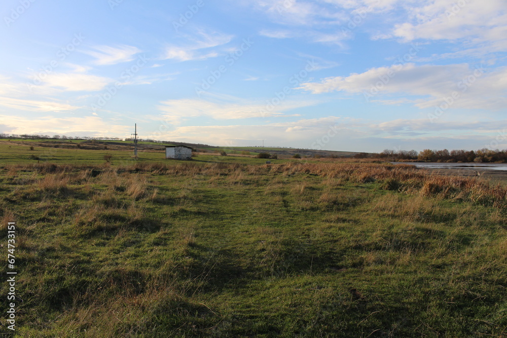 A grassy field with a building in the distance A grassy field with a building in the distance