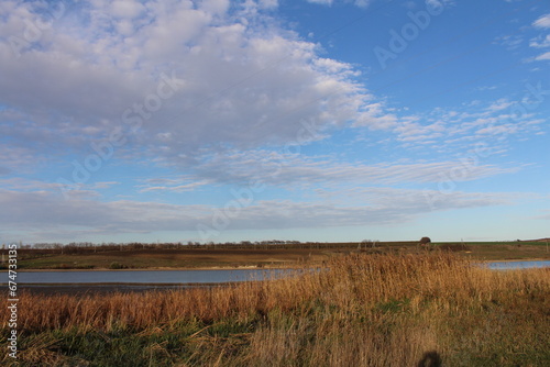 A field with grass and a body of water in the distance