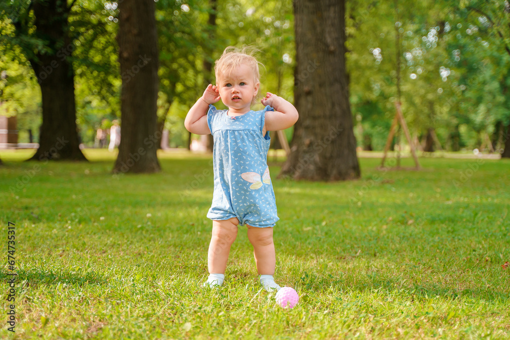 Cute baby child girl enjoys summer in a green park Cute baby child girl enjoys summer in a green park