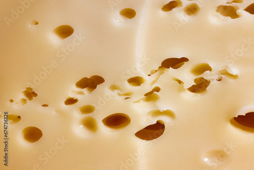 Texture of cheese with wholes, emmental, maasdam, radamer. Close-up image o delicious cheese. Organic swiss cheese. Concept of food, taste, art of organic products, healthy, natural food. photo