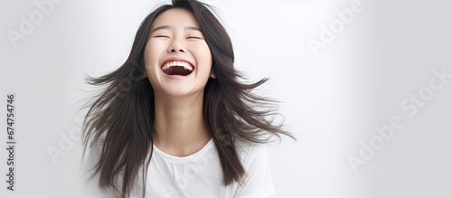 In the isolated white space a happy Chinese girl with a cute smile shines in her portrait radiating a background of joy and a funny personality that captivates people and empowers women ever