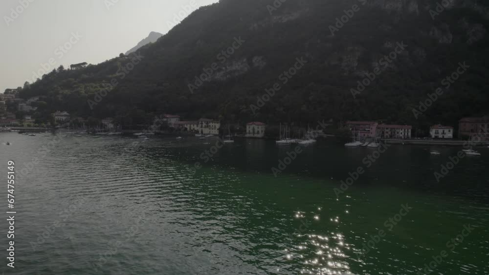 Aerial view of the coastline of Lake Como with boats anchored along the shore near Lecco, Italy. Aerial view of the coastline of Lake Como with boats anchored along the shore near Lecco, Italy.