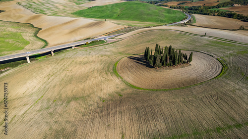 Italy landscape. Amazing Tuscany scenery. Typical countryside with vast fields of Val d'Orcia famous beautiful valley. Aerial drone shot of circle cypresses trees, high angle view