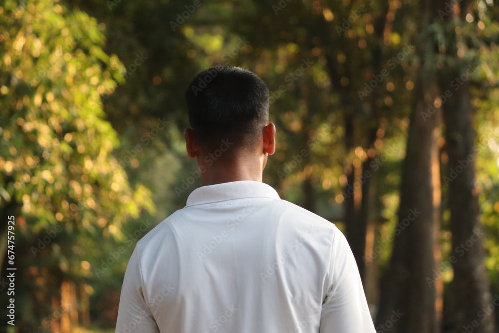 A man in white tshirt and short hair going towards deep jungle to feel relax an calm