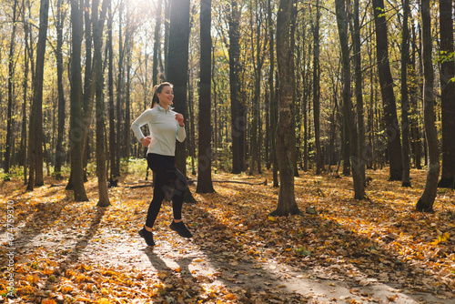 Beautiful girl doing fitness in nature on a sunny autumn forest. Body positive, sports for women, harmony, healthy lifestyle, self-love and wellness.