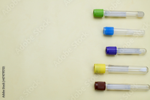 Vacuum tubes for collection and blood samples on yellow background with space for text