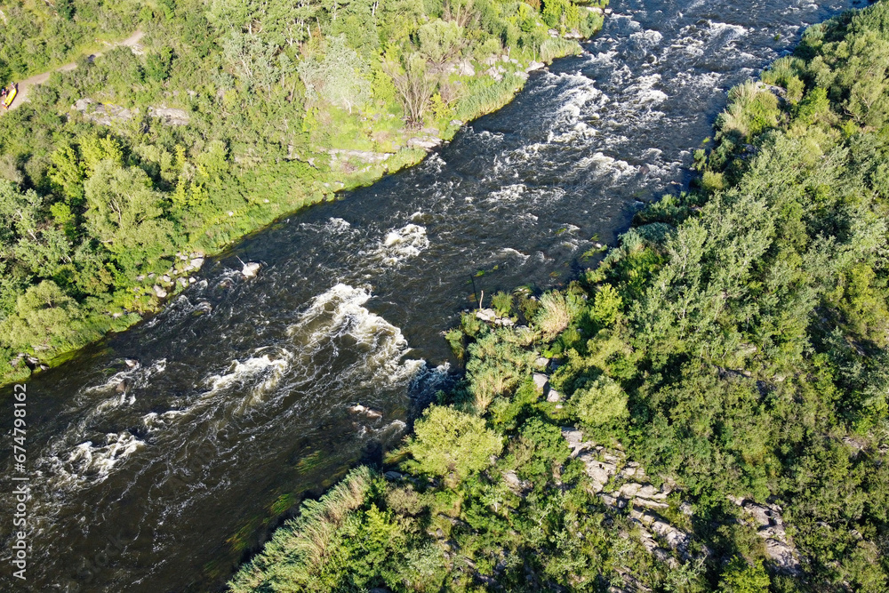 Picturesque river rapids on the Southern Bug. Rapid flow of the river over rocky terrain, landscape from a bird's eye view.