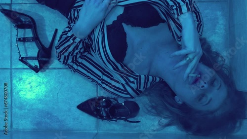 artificial paradise - stoned girl lying on the floor smokes hashish photo