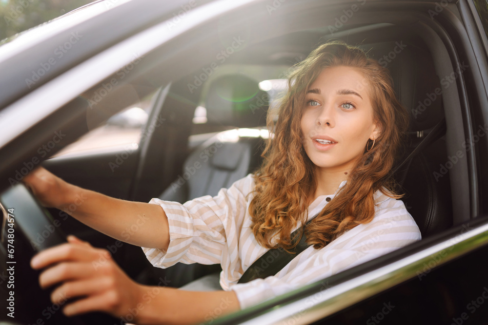 Smiling woman driving her car. Portrait of a stylish woman in casual clothes driving a car. Car travel concept.