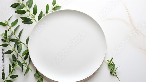 On a light surface, an oval ceramic plate with a laconic decor, green leaves, ceramic studio, copyspace, hobby, handmade, top view, table texture, glossy, clay plate, white, stalk, minimalism, dirty