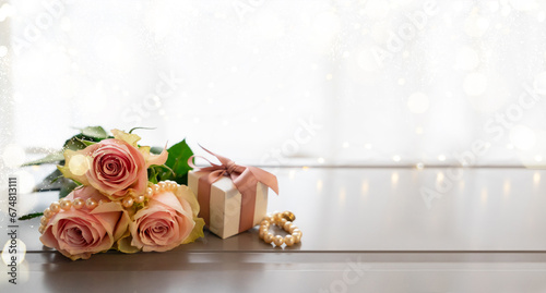 Rose fresh flowers bouquet on gray table by the window with gift box banner