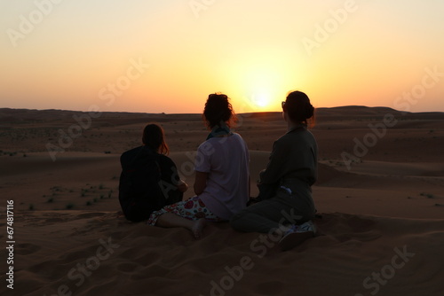 Amies devant couché de soleil - Oman
