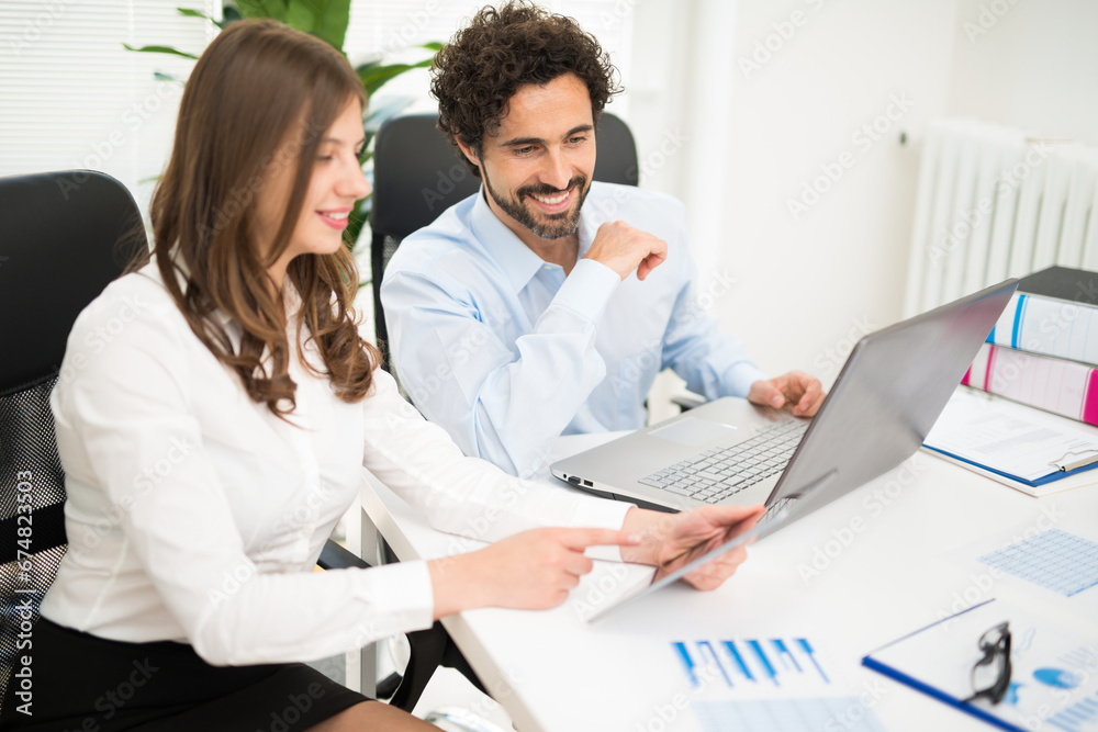 Smiling business people using a laptop computer Smiling business people using a laptop computer