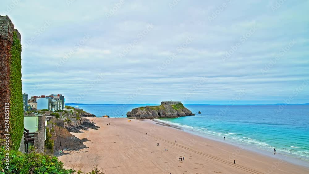 Tourists visit Tenby Harbour Town and Resort in southwest Wales. People enjoy Welsh vacation with sandy beaches and colourful houses in Wales. Tourists visit Tenby Harbour Town and Resort in southwest Wales. People enjoy Welsh vacation with sandy beaches and colourful houses in Wales.