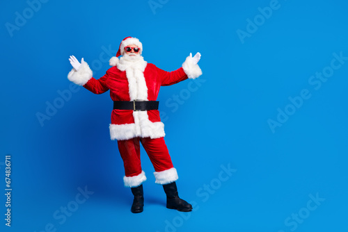 Full length photo of mature pensioner man raise hands hello dressed stylish santa claus costume coat isolated on blue color background