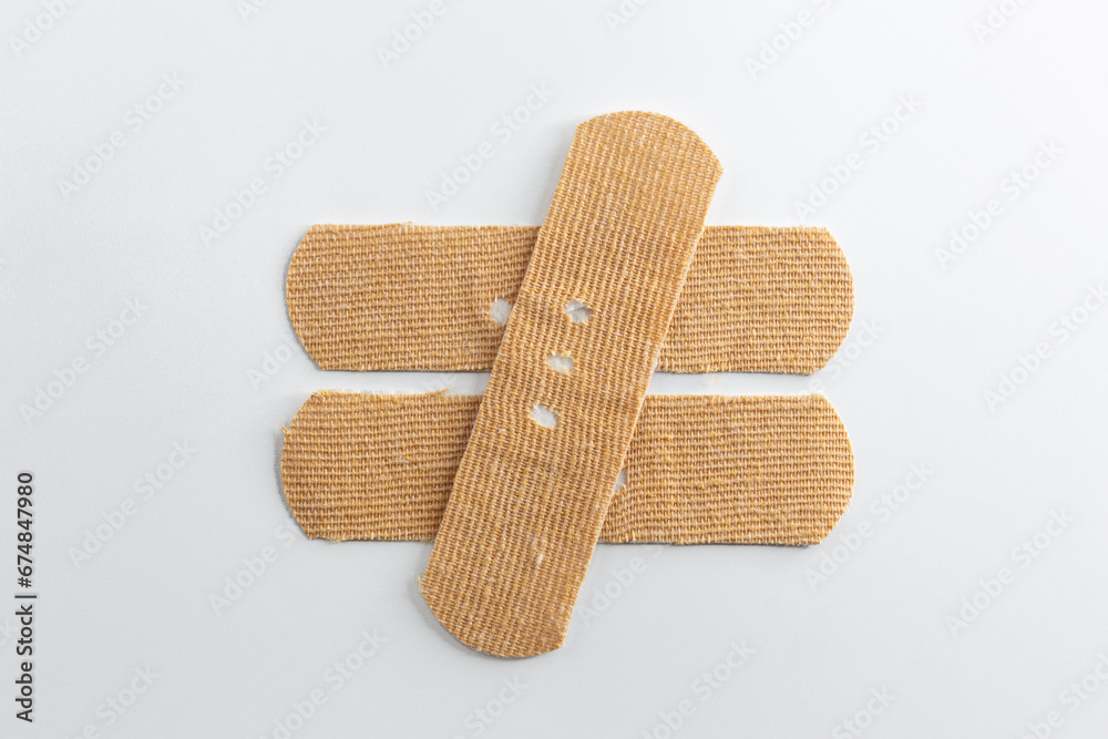 Band-Aids on a white background. Mathematical sign made with band-aids, not equal. Band-Aids on a white background. Mathematical sign made with band-aids, not equal.