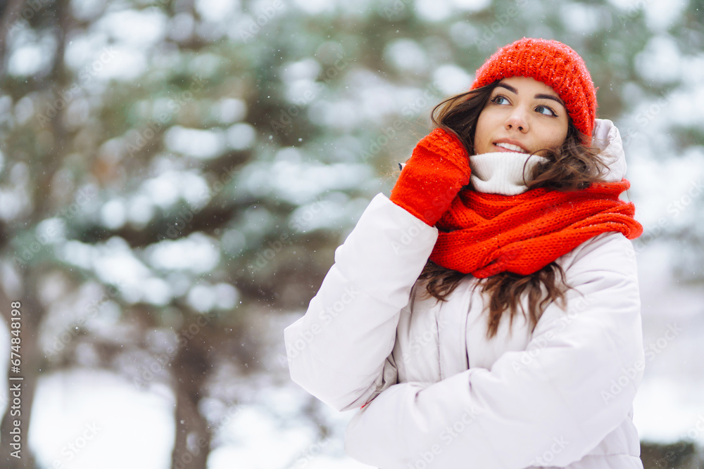 Portrait of a beautiful woman in a red hat in a snowy forest. Young woman having fun with snow on a winter day. Vacation concept, nature. Portrait of a beautiful woman in a red hat in a snowy forest. Young woman having fun with snow on a winter day. Vacation concept, nature.
