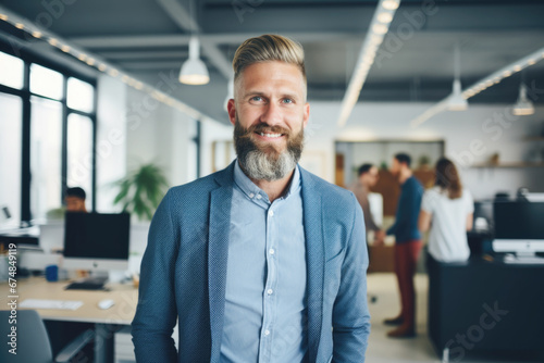 Confident and smiling handsome hipster man standing in the office 