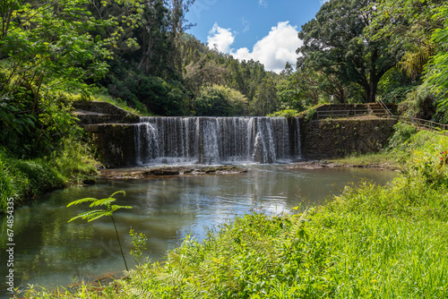 Fototapeta Naklejka Na Ścianę i Meble -  A stone dam with beautiful waterfall in Kauai, Hawaii, United States.

