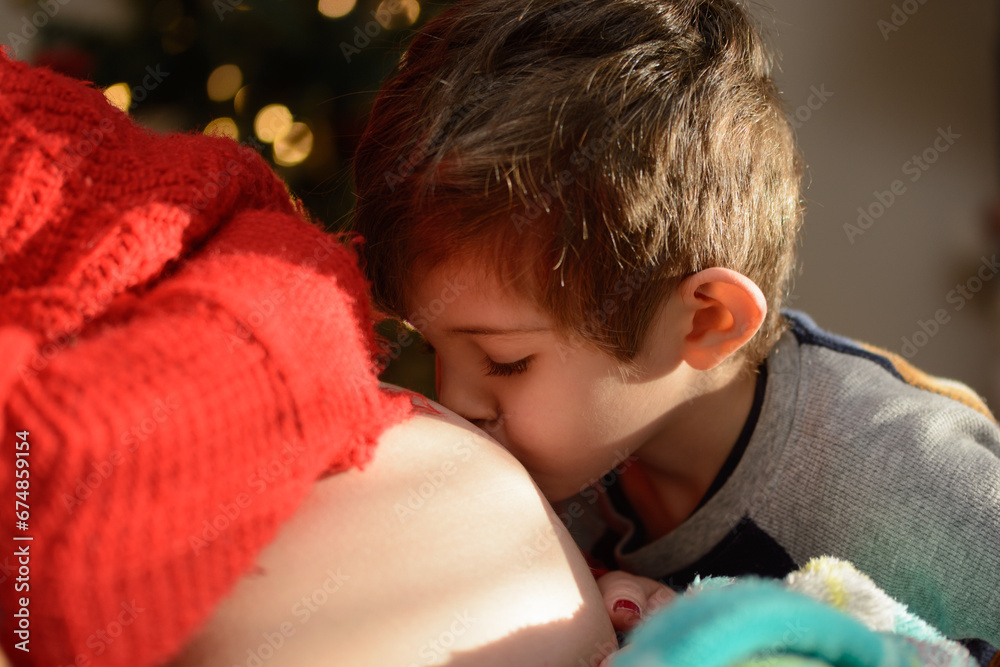 Young boy kissing his mother's pregnant belly Young boy kissing his mother's pregnant belly