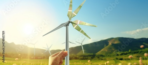 ESG and Clean Energy Concept. Hand Raise up a Wind Turbine Paper into the Sky. Decrease Carbon and Produce a Green Power. World Earth Day, Sustainable Resources, Environmental Care. Wind energy.