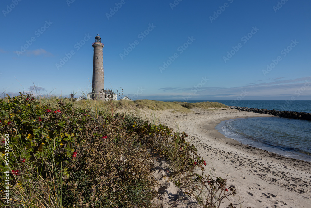 Grey lighthouse and sand dunes by the Baltic Sea in Denmark.
