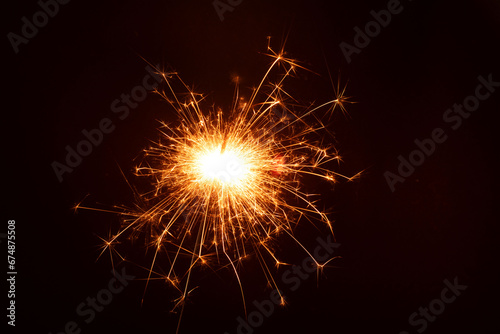 photography the bright glow of a sparkler in the dark, creating a merry and celebratory atmosphere. With ample copy space, it's perfect for New Year or holiday-themed designs.photo