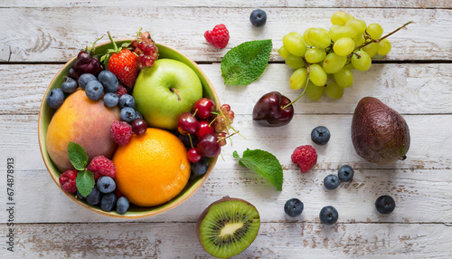 Fruit salad with berries in the bowl on the wooden background .