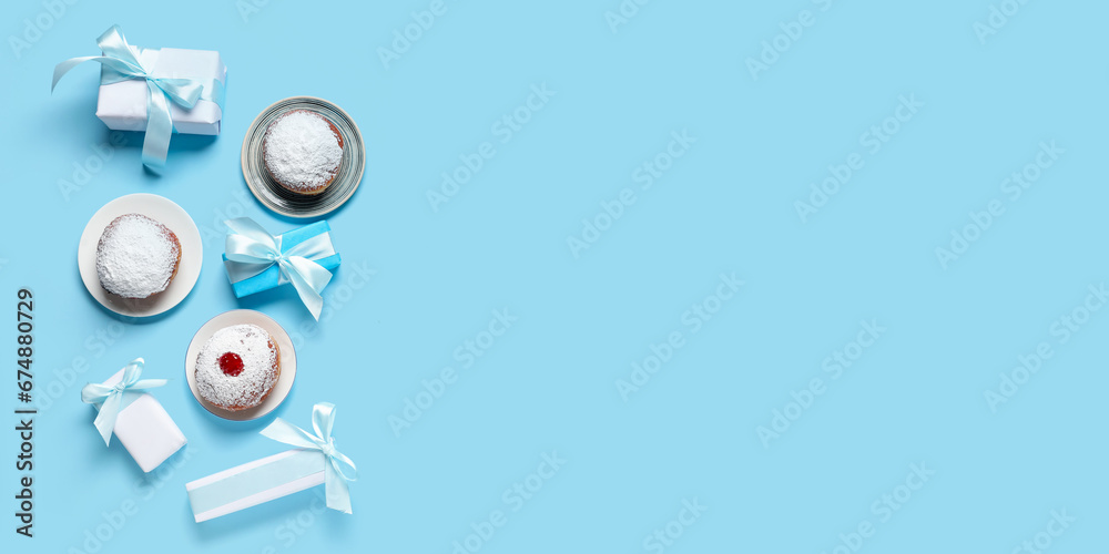 Donuts and gifts on light blue background with space for text. Hanukkah celebration