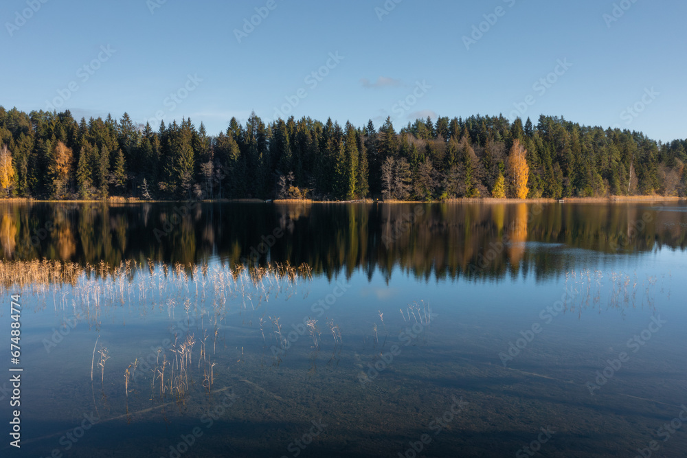 Picturesque landscape of bank of the lake Bolduk in sunny autumn day. Hiking near the lake along the Blue Lakes tourist route.