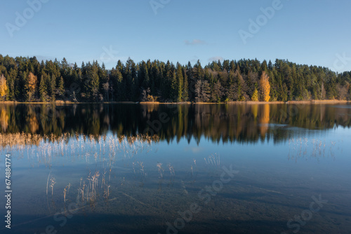 Obraz na płótnie Picturesque landscape of bank of the lake Bolduk in sunny autumn day. Hiking near the lake along the Blue Lakes tourist route. w salonie