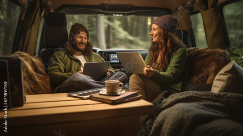 Man and woman with dog traveling together on transport - Freelance nomad concept with hippie people on car romantic trip working at laptop pc in relax moment photo